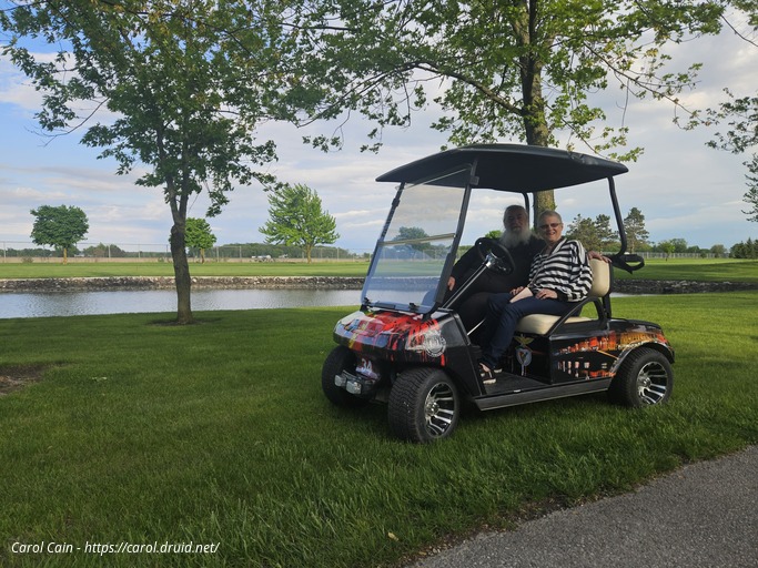 Carol and D'Arcy in our new golf cart 2025
